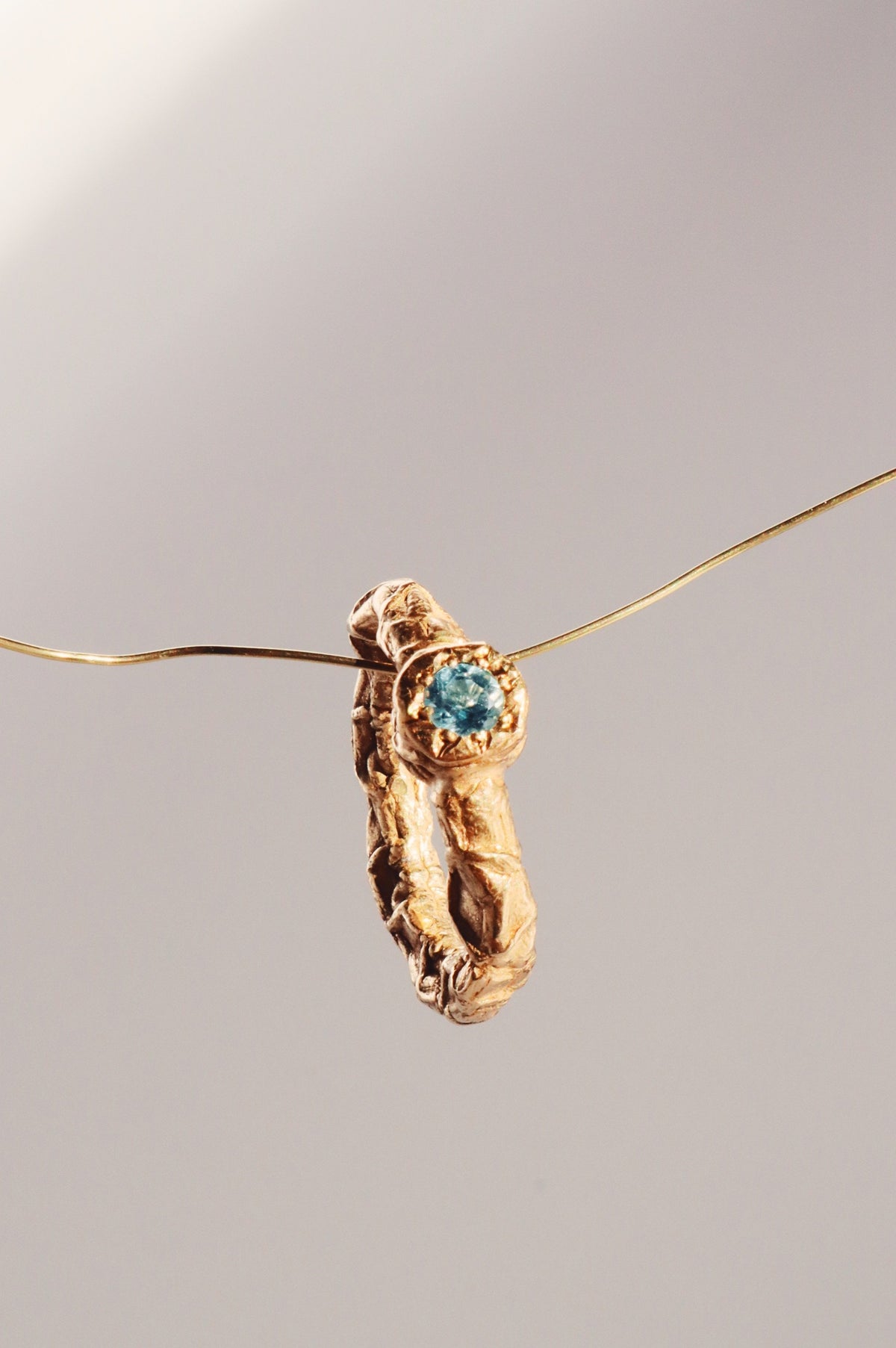 Gold Galaxia ring with a blue topaz, hanging on a fine chain, by Bocavolcan
